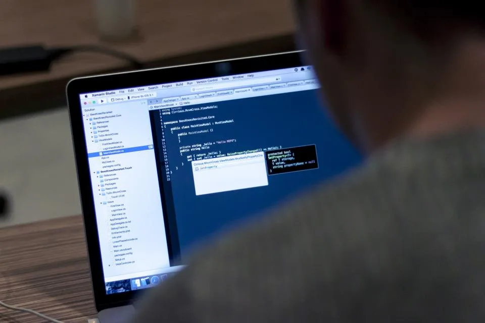 A laptop mid-edit, an editor open on a class file